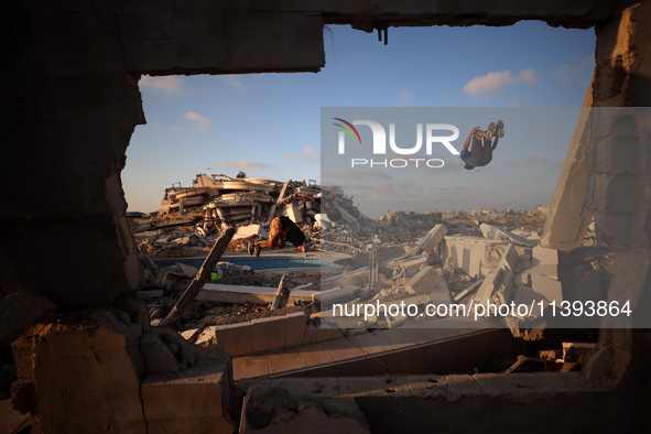 Palestinian youths are playing parkour at the ruins of a building destroyed in recent Israeli air strikes, in Zawayda, in the central Gaza S...