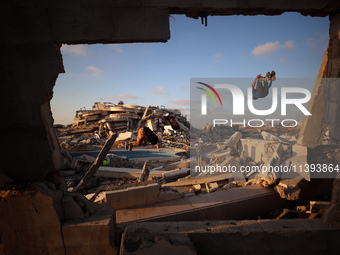 Palestinian youths are playing parkour at the ruins of a building destroyed in recent Israeli air strikes, in Zawayda, in the central Gaza S...