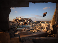 Palestinian youths are playing parkour at the ruins of a building destroyed in recent Israeli air strikes, in Zawayda, in the central Gaza S...