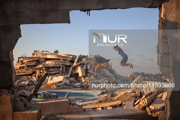 Palestinian youths are playing parkour at the ruins of a building destroyed in recent Israeli air strikes, in Zawayda, in the central Gaza S...