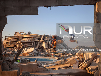 Palestinian youths are playing parkour at the ruins of a building destroyed in recent Israeli air strikes, in Zawayda, in the central Gaza S...