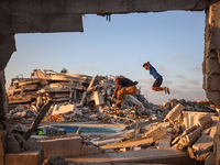 Palestinian youths are playing parkour at the ruins of a building destroyed in recent Israeli air strikes, in Zawayda, in the central Gaza S...