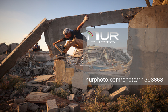 A Palestinian youth is practicing parkour at the ruins of a building destroyed in recent Israeli air strikes, in Zawayda in the central Gaza...