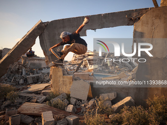 A Palestinian youth is practicing parkour at the ruins of a building destroyed in recent Israeli air strikes, in Zawayda in the central Gaza...