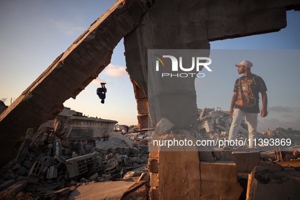 Palestinian youths are playing parkour at the ruins of a building destroyed in recent Israeli air strikes, in Zawayda, in the central Gaza S...