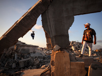 Palestinian youths are playing parkour at the ruins of a building destroyed in recent Israeli air strikes, in Zawayda, in the central Gaza S...