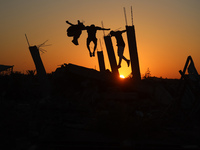 Palestinian youths are playing parkour at the ruins of a building destroyed in recent Israeli air strikes, in Zawayda, in the central Gaza S...