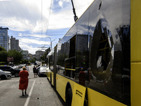 People are walking in a street covered with debris past a damaged trolleybus after a Russian missile strike in Kyiv, Ukraine, on July 08, 20...