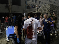 Rescuers and volunteers are working at Ohmatdyt Children's Hospital that was strongly damaged during a Russian missile strike in Kyiv, Ukrai...