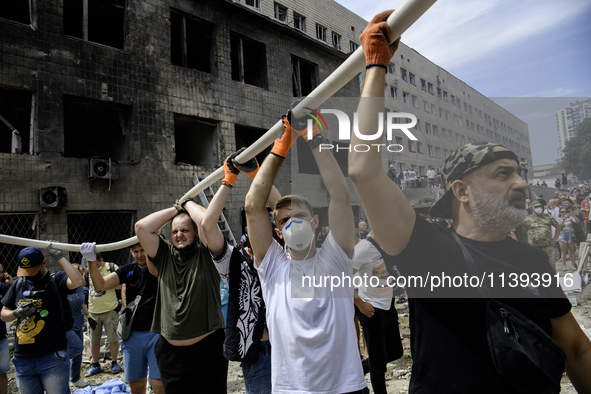 Rescuers and volunteers are working at Ohmatdyt Children's Hospital that was strongly damaged during a Russian missile strike in Kyiv, Ukrai...