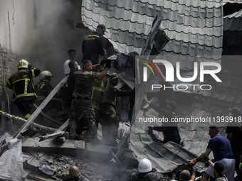 Rescuers and volunteers are working at Ohmatdyt Children's Hospital that was strongly damaged during a Russian missile strike in Kyiv, Ukrai...