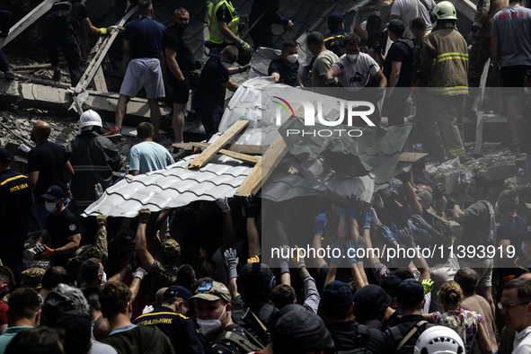 Rescuers and volunteers are working at Ohmatdyt Children's Hospital that was strongly damaged during a Russian missile strike in Kyiv, Ukrai...