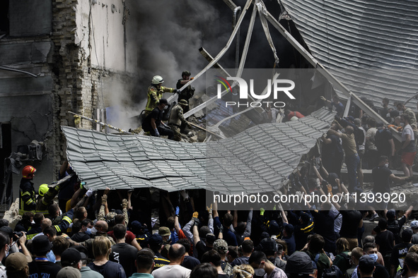 Rescuers and volunteers are working at Ohmatdyt Children's Hospital that was strongly damaged during a Russian missile strike in Kyiv, Ukrai...