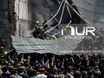 Rescuers and volunteers are working at Ohmatdyt Children's Hospital that was strongly damaged during a Russian missile strike in Kyiv, Ukrai...