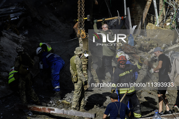 Rescuers and volunteers are working at Ohmatdyt Children's Hospital that was strongly damaged during a Russian missile strike in Kyiv, Ukrai...