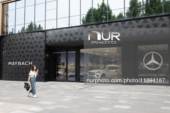 A citizen is passing the Mercedes-Maybach City Brand Center at the BFC Bund Financial Center in Huangpu District in Shanghai, China, on July...