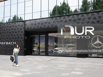 A citizen is passing the Mercedes-Maybach City Brand Center at the BFC Bund Financial Center in Huangpu District in Shanghai, China, on July...