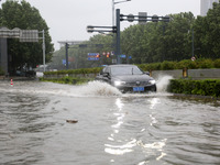 Vehicles are driving slowly through water on a road in Lianyun district, Lianyungang city, East China's Jiangsu province, on July 9, 2024. (