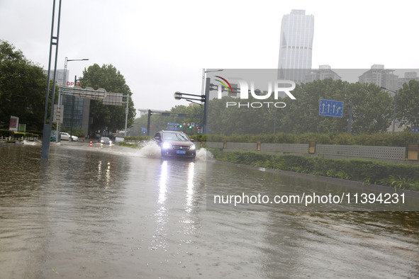 Vehicles are driving slowly through water on a road in Lianyun district, Lianyungang city, East China's Jiangsu province, on July 9, 2024. 