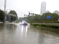 Vehicles are driving slowly through water on a road in Lianyun district, Lianyungang city, East China's Jiangsu province, on July 9, 2024. (