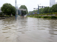 Vehicles are driving slowly through water on a road in Lianyun district, Lianyungang city, East China's Jiangsu province, on July 9, 2024. (