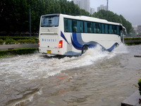 Vehicles are driving slowly through water on a road in Lianyun district, Lianyungang city, East China's Jiangsu province, on July 9, 2024. (