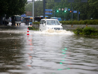 Vehicles are driving slowly through water on a road in Lianyun district, Lianyungang city, East China's Jiangsu province, on July 9, 2024. (