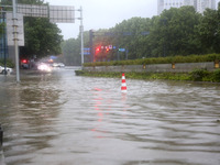 Vehicles are driving slowly through water on a road in Lianyun district, Lianyungang city, East China's Jiangsu province, on July 9, 2024. (