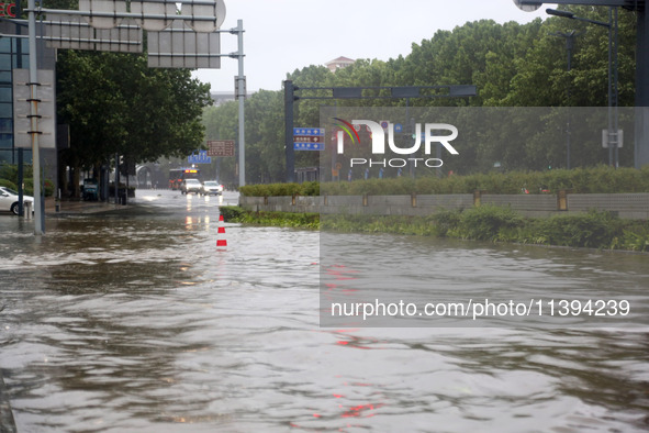 Vehicles are driving slowly through water on a road in Lianyun district, Lianyungang city, East China's Jiangsu province, on July 9, 2024. 