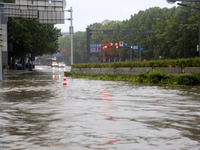 Vehicles are driving slowly through water on a road in Lianyun district, Lianyungang city, East China's Jiangsu province, on July 9, 2024. (