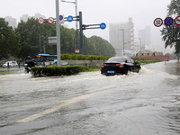 Vehicles are driving slowly through water on a road in Lianyun district, Lianyungang city, East China's Jiangsu province, on July 9, 2024. (