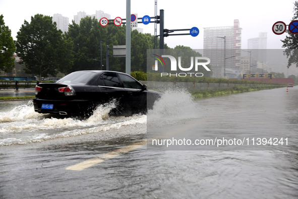 Vehicles are driving slowly through water on a road in Lianyun district, Lianyungang city, East China's Jiangsu province, on July 9, 2024. 