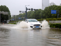 Vehicles are driving slowly through water on a road in Lianyun district, Lianyungang city, East China's Jiangsu province, on July 9, 2024. (