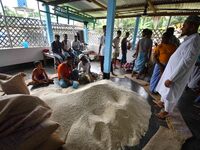 Flood-affected people are receiving food supplies at a relief center during flooding in a low-lying area in Nagaon District of Assam, India,...