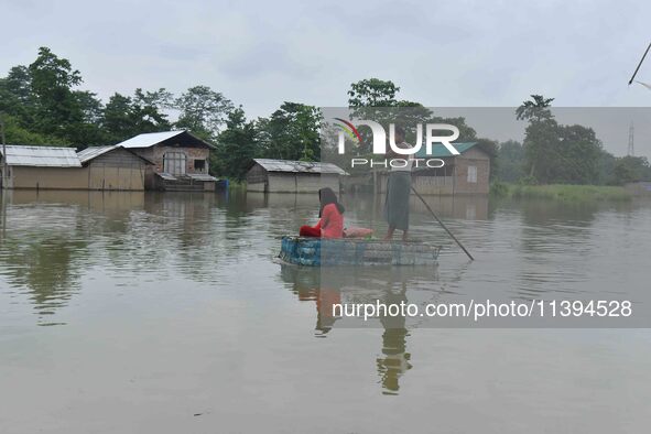 A man is rowing a makeshift raft on floodwater near his house in Nagaon district of Assam, India, on July 9, 2024. 