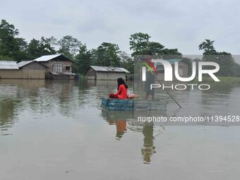 A man is rowing a makeshift raft on floodwater near his house in Nagaon district of Assam, India, on July 9, 2024. (