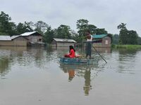 A man is rowing a makeshift raft on floodwater near his house in Nagaon district of Assam, India, on July 9, 2024. (