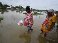 People are moving through a flooded road after heavy rainfall in Nagaon district of Assam, India, on July 9, 2024. (