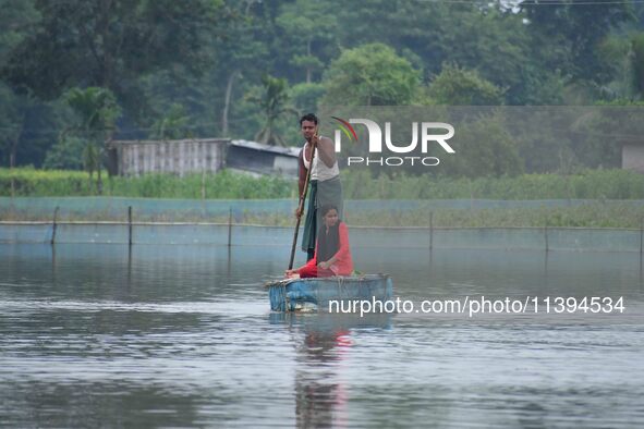 A man is rowing a makeshift raft on floodwater near his house in Nagaon district of Assam, India, on July 9, 2024. 