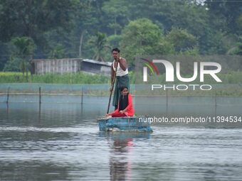 A man is rowing a makeshift raft on floodwater near his house in Nagaon district of Assam, India, on July 9, 2024. (