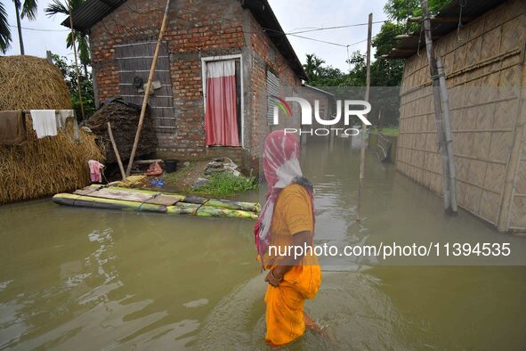 A woman is moving through a flooded road after heavy rainfall in Nagaon district of Assam, India, on July 9, 2024. 