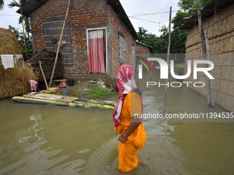 A woman is moving through a flooded road after heavy rainfall in Nagaon district of Assam, India, on July 9, 2024. (