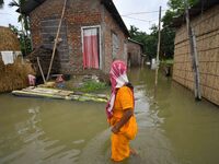 A woman is moving through a flooded road after heavy rainfall in Nagaon district of Assam, India, on July 9, 2024. (