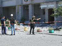 Men are staying behind a caution tape sealing off an apartment block damaged by the Russian missile attack in Dnipro, Ukraine, on July 8, 20...