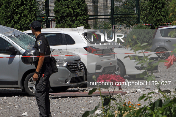 A police officer is standing behind caution tape near cars damaged by the Russian missile attack in Dnipro, Ukraine, on July 8, 2024. NO USE...