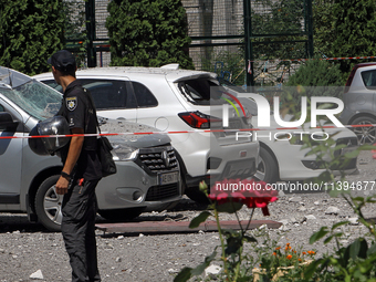 A police officer is standing behind caution tape near cars damaged by the Russian missile attack in Dnipro, Ukraine, on July 8, 2024. NO USE...