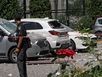 A police officer is standing behind caution tape near cars damaged by the Russian missile attack in Dnipro, Ukraine, on July 8, 2024. NO USE...