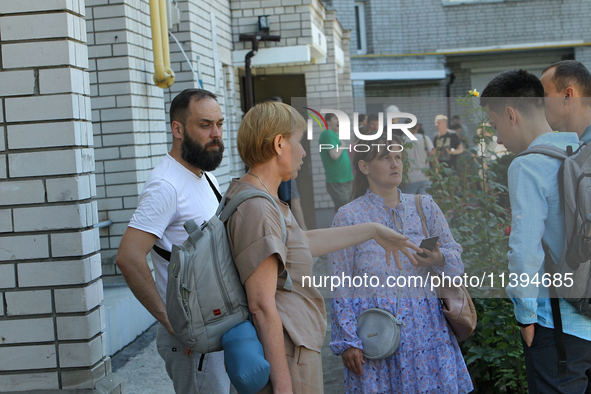 Residents are staying outside an apartment block damaged by the Russian missile attack in Dnipro, Ukraine, on July 8, 2024. NO USE RUSSIA. N...