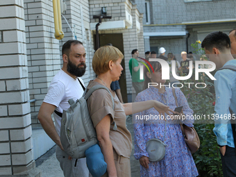 Residents are staying outside an apartment block damaged by the Russian missile attack in Dnipro, Ukraine, on July 8, 2024. NO USE RUSSIA. N...