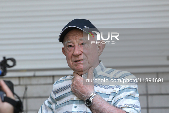 An elderly man is speaking to the press outside an apartment block damaged by the Russian missile attack in Dnipro, Ukraine, on July 8, 2024...